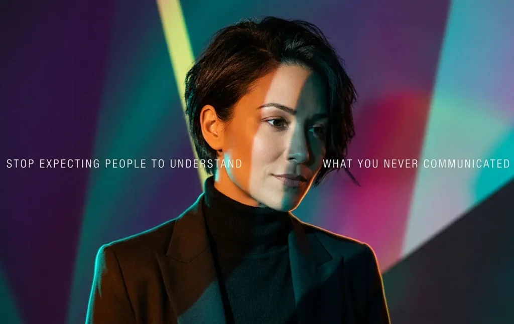 A woman with thoughtful expression in dramatic colored lighting, illustrating the importance of Emotional intelligence in relationships by communicating clear expectations