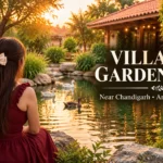 Villagio Garden Cafe near Chandigarh review featuring a woman in a burgundy dress sitting beside a garden pond surrounded by greenery and ducks.